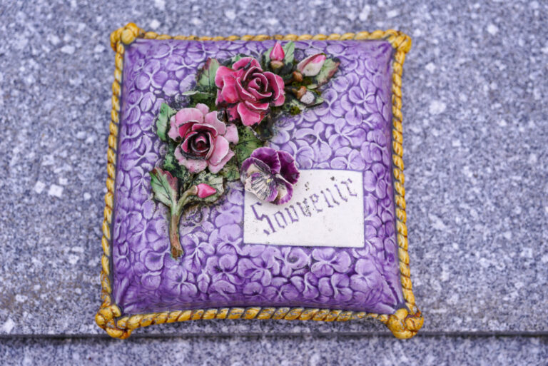 France, Chatellerault, 2019-09-29. Des roses en ceramiques reposent sur un coussin de violettes, en ceramique lui aussi.